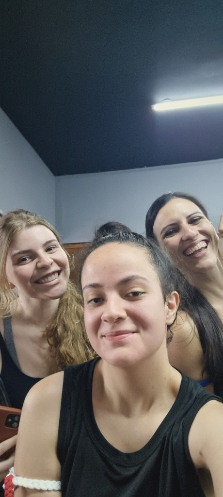Selfie sorridente de alunas do estúdio de Muay Thai no tatame